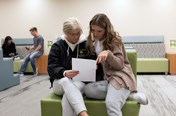 two people looking over a paper 