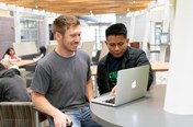 two people looking at a laptop