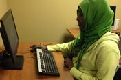 woman with head scarf operating computer
